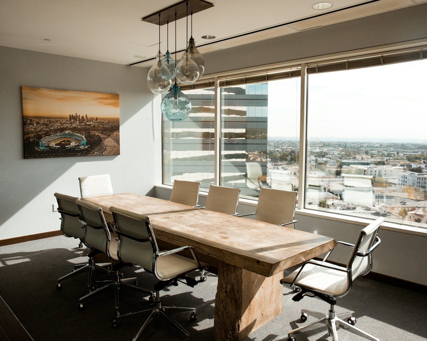 A boardroom with a long table and a city view